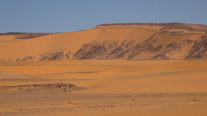 A trip to Sahara desert in Algeria. Beautiful 
african travel photo. Sandy landscapes, mountains, rocks,
dunes, and nature. Summer vacation in arab country.