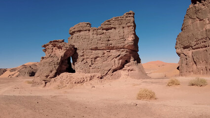 Fototapeta premium A trip to Sahara desert in Algeria. Beautiful african travel photo. Sandy landscapes, mountains, rocks, dunes, and nature. Summer vacation in arab country.