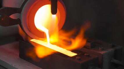 Gold Smelting Process with Blue Flame Heating Metal Bars in Industrial Foundry Equipment