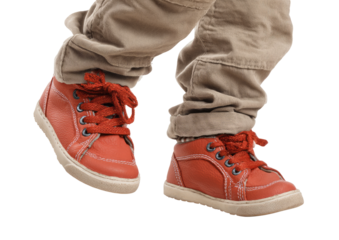 Child's feet in red shoes and tan pants, walking
