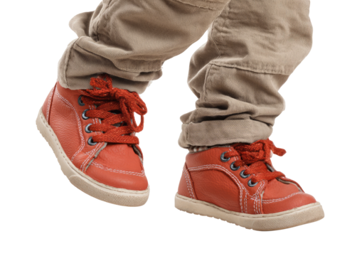 Child's feet in red shoes and tan pants, walking