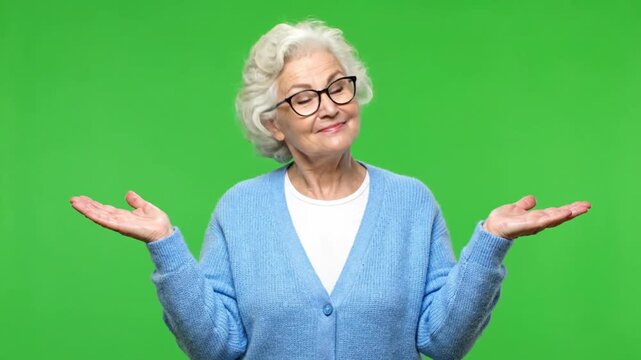 Confused senior woman shrugging shoulders on green screen background.