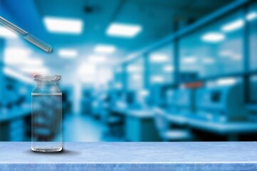 A drop of liquid falls from a glass pipette