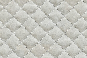 Naklejka premium Quilted fabric texture background with a classic geometric diamond pattern and soft padding. Ideal for textiles upholstery and creative design projects.