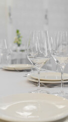 wedding, festive white table setting. Plates, cutlery, glasses, flower arrangement, white tablecloth