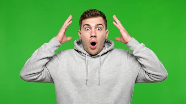 Surprised Young Man in Hoodie Reacts with Amazement on Green Screen.