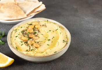 Lupini bean hummus with olive oil, herbs and pita bread on dark background. Vegetarian food. 