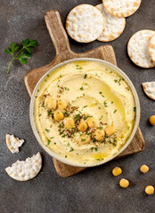 Lupini hummus with herbs, crackers, lemon on dark background. Healthy vegan snack. Top view.