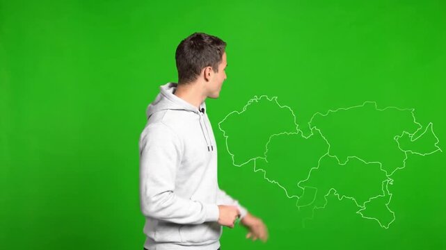 Young Man Presenting with a Digital Map on a Green Screen Background.
