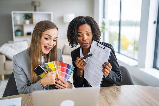 Businesswomen collaborating on video call holding color swatch