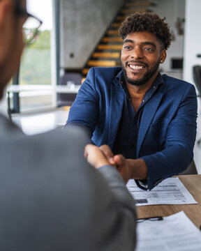 Business partners shaking hands initiating new professional agreement