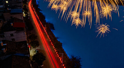 Long Exposure of a Diwali Fireworks Display with Red Traffic Light Trails at Night