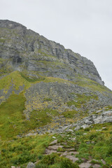 Majestic cliff and mountain wall under cloudy sky, Norway