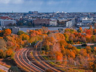 Aerial late afternoon view of Riga, Latvia with railway tracks curving through a park toward the...