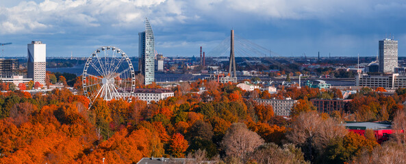 Aerial view of Riga, Latvia, shows golden trees, Z Towers, Vansu Bridge, Daugava River, and a...