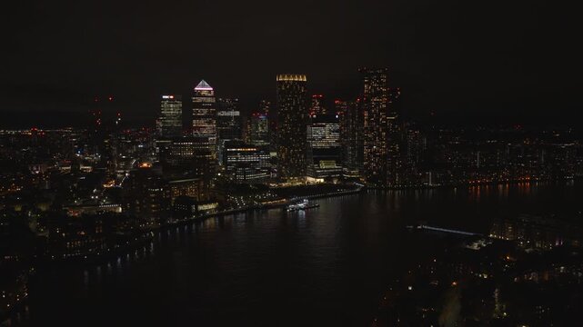 Aerial view of Canary Wharf at night. London financial district illuminated with city lights