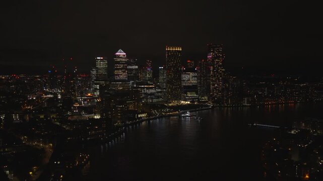 Aerial view of Canary Wharf at night. London financial district illuminated with city lights