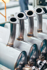 Galvanized steel car muffler with exhaust pipes in batch for assembling on automotive industry.