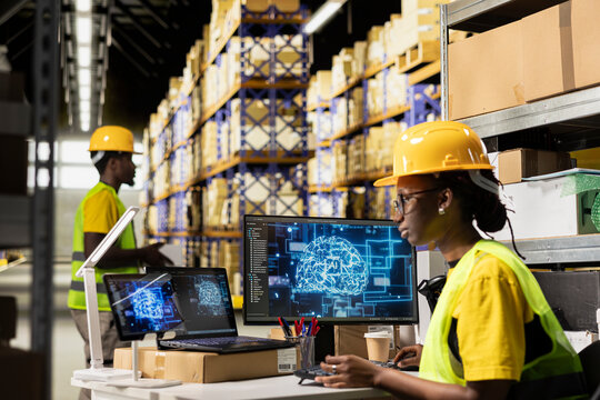 Distribution hub employee working with AI brain data science in warehouse with huge storage racks and shelves, order fulfillment for import export operations. Black woman uses machine learning.