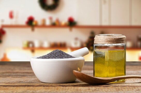 Black cumin herbal oil and seeds on wooden desk