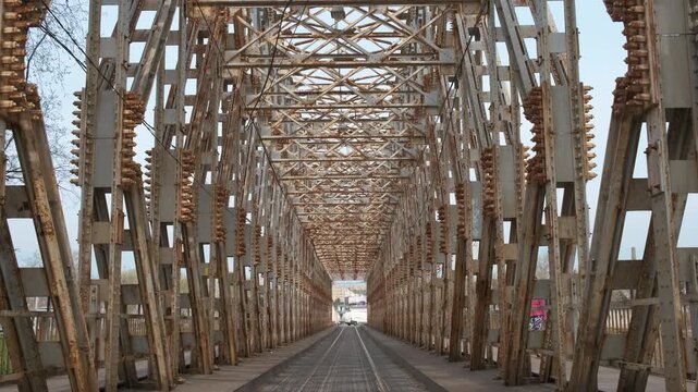 Rusty beams of urban bridge. A view of rusty beams of old railway bridge against sky in the city