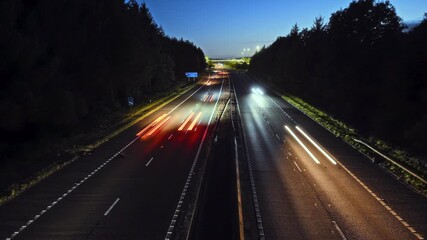Time-lapse video of highway at night with colorful light trails from cars. Concept of speed, motion and modern transportation. Scotland - Powered by Adobe