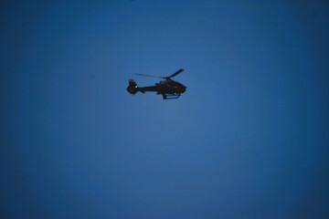 Helicopter Silhouette Against Bright Blue Sky