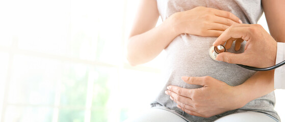 Doctor examining pregnant woman in clinic