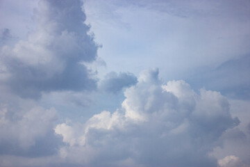 Soft blue sky with large fluffy white clouds creating a peaceful and natural atmosphere. Perfect for weather, nature, or calm background themes.