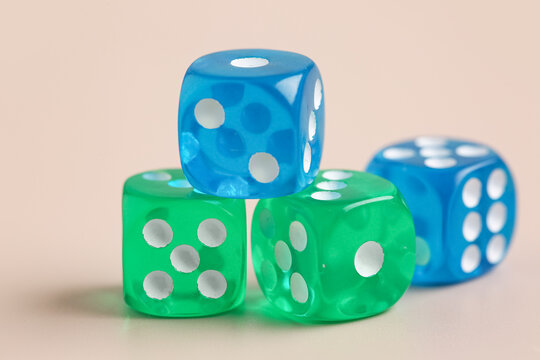 Blue and green game dices on beige background