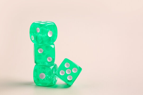 Green game dices on beige background