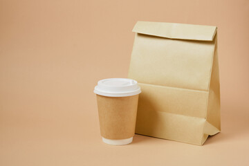 cup coffee and paper bag on beige background Coffee and takeaway, mockup, fast food, eco-friendly packaging