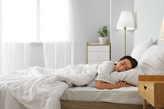 Fototapeta Morning of young Asian woman sleeping under blanket in bedroom