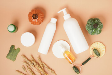 Cosmetics products and autumn decor on a beige background