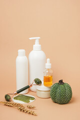 Cosmetics products and autumn decor on a beige background
