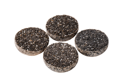 Four dark, round, speckled food items, arranged in a loose, slightly overlapping pattern against a black background.  The specks are small and uniformly distributed across each disk