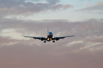 Passenger Airplane Flying Above Vibrant Evening Clouds