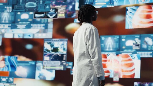 Portrait of healthcare specialist looking at CT scans, MRI data, and lab analytics displayed on videowall. Scientist in medical research lab reading health data on high tech digital panels, camera B - Powered by Adobe