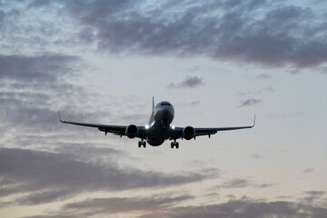 Commercial Jet Descending Against Vibrant Evening Clouds