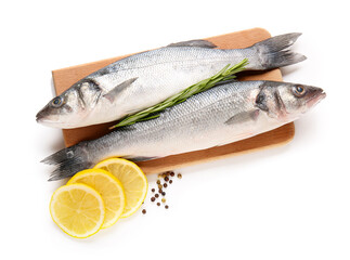 Board, fresh uncooked sea bass fish, slices of lemon and black pepercorns isolated on white background, closeup