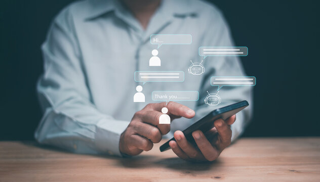 Chatbot communication concept. Businessman using smartphone and digital AI chat interface. Representing online customer service, automation, artificial intelligence and virtual assistant technology.
