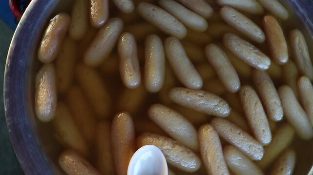 Sweet rasgulla, simmering in a sweet syrup in a large cauldron.