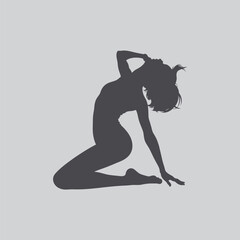 Fototapeta premium A silhouetted woman kneeling with her head bowed in a graceful pose