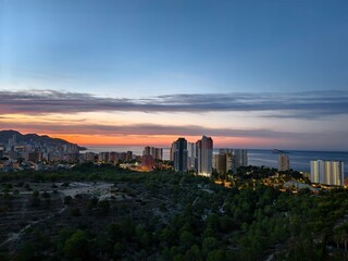 Obraz premium Breathtakingly stunning sunset view over a coastal cityscape featuring highrise buildings