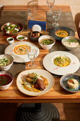 A Delicious Spread of Gourmet Dishes Arranged Flawlessly on a Beautiful Wooden Table