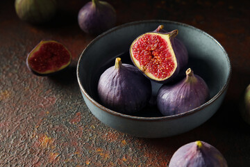 Bowl with fresh ripe figs on dark background, closeup