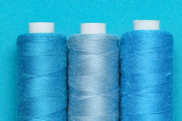 Spools of thread on blue background, closeup