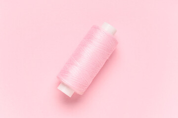 Spool of thread on pink background