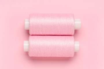 Spools of thread on pink background