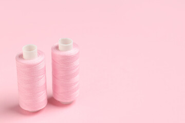 Spools of thread on pink background
